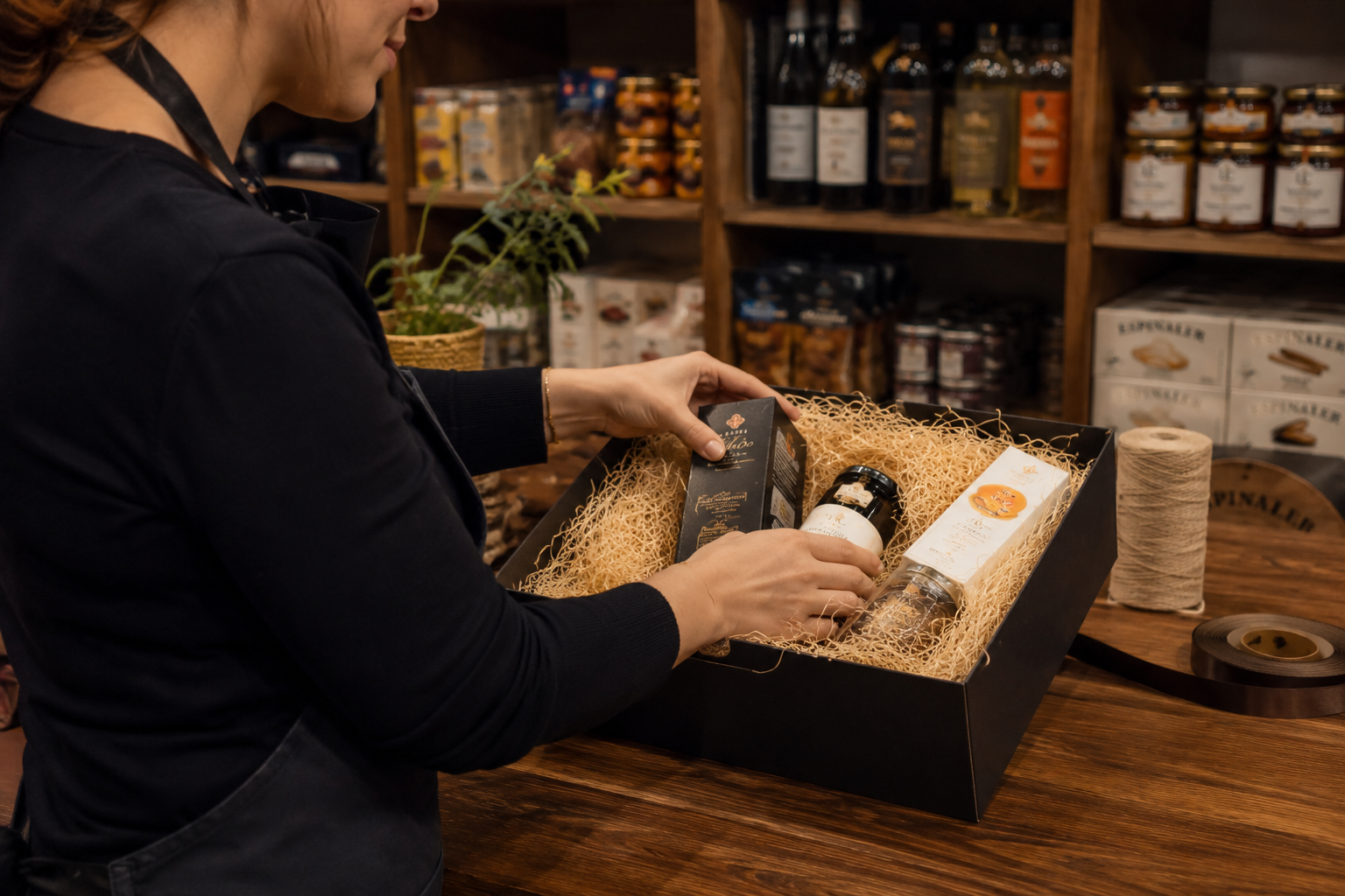 Preparación artesanal de una cesta gourmet en tienda